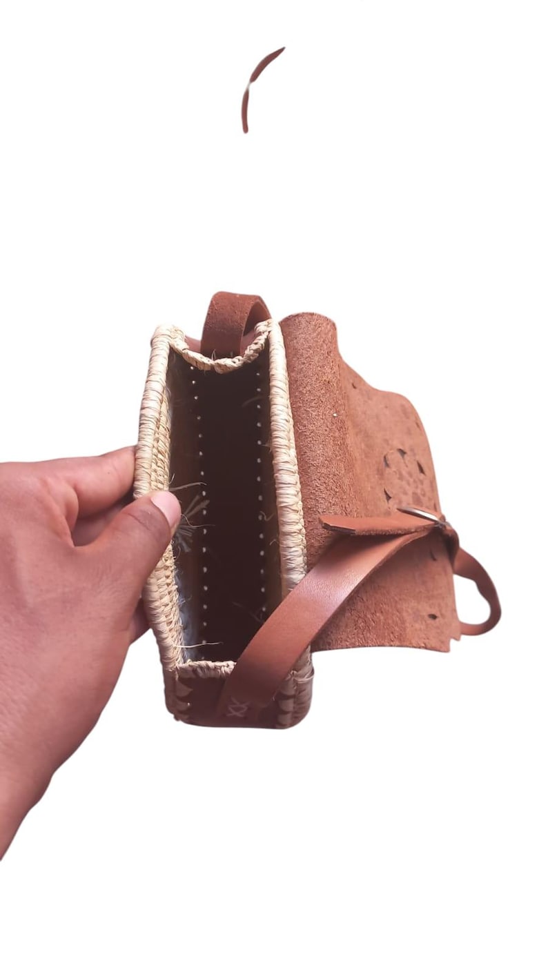 Détail rabat en cuir et bordure en paille tressée